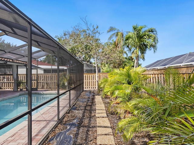 view of yard with glass enclosure and a fenced in pool