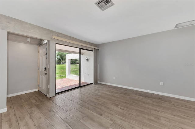 empty room with visible vents, baseboards, and light wood-type flooring