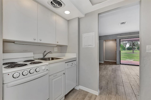 kitchen with white appliances, light wood-style flooring, a sink, white cabinetry, and visible vents