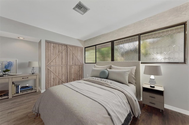 bedroom featuring visible vents, wood finished floors, and baseboards