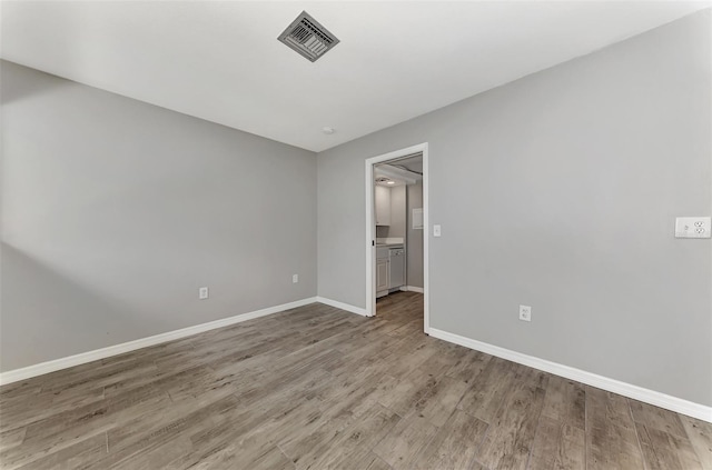 interior space with wood finished floors, visible vents, and baseboards