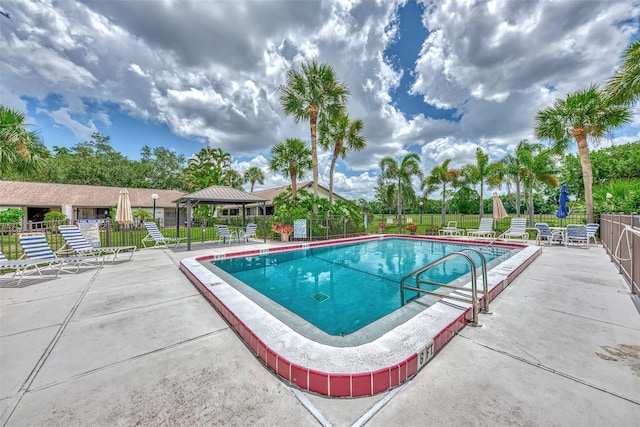 pool featuring fence, a gazebo, and a patio