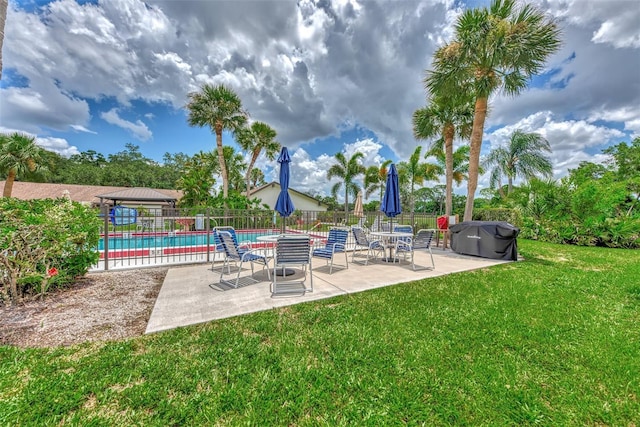 view of swimming pool featuring a pool, fence, a yard, and a patio area