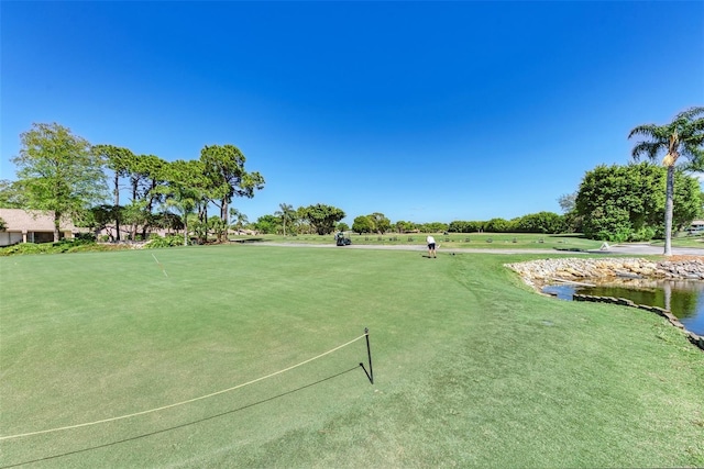 surrounding community with golf course view and a water view