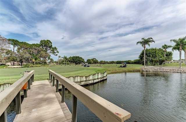 view of dock featuring a lawn and a water view