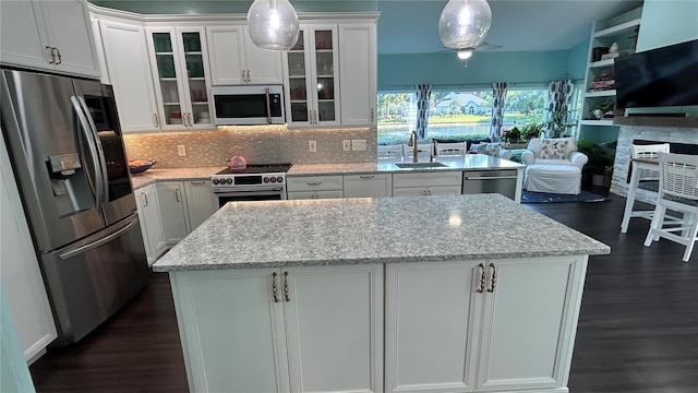 1600 Twin Oaks Cir, Oviedo, FL 32765 - kitchen with a center island, appliances with stainless steel finishes, a sink, and dark wood-type flooring