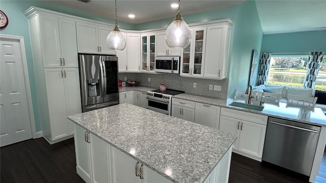 1600 Twin Oaks Cir, Oviedo, FL 32765 - kitchen featuring dark wood finished floors, a sink, tasteful backsplash, appliances with stainless steel finishes, and white cabinetry