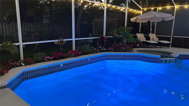 1600 Twin Oaks Cir, Oviedo, FL 32765 - pool at night featuring glass enclosure, fence, a fenced in pool, and an in ground hot tub