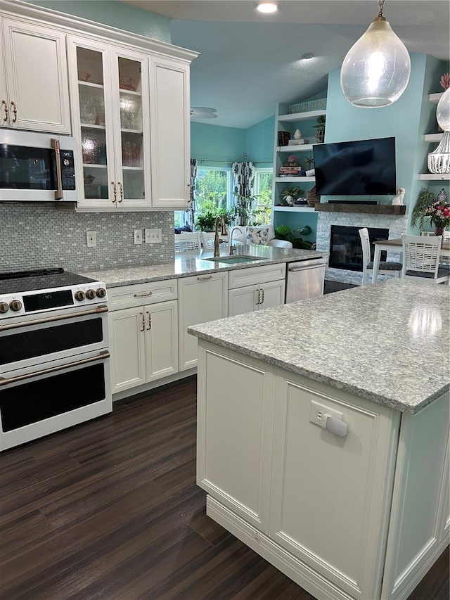 1600 Twin Oaks Cir, Oviedo, FL 32765 - kitchen with white cabinets, dark wood-style floors, a sink, range with two ovens, and dishwasher