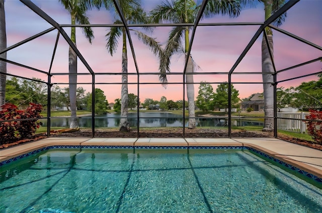 14315 Tree Swallow Way, Lakewood Ranch, FL 34202 - pool at dusk featuring glass enclosure, a water view, and an outdoor pool