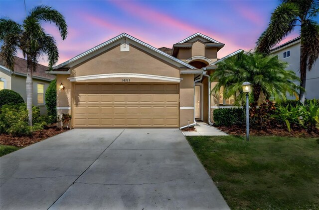 14315 Tree Swallow Way, Lakewood Ranch, FL 34202 - view of front of home with stucco siding, an attached garage, and concrete driveway