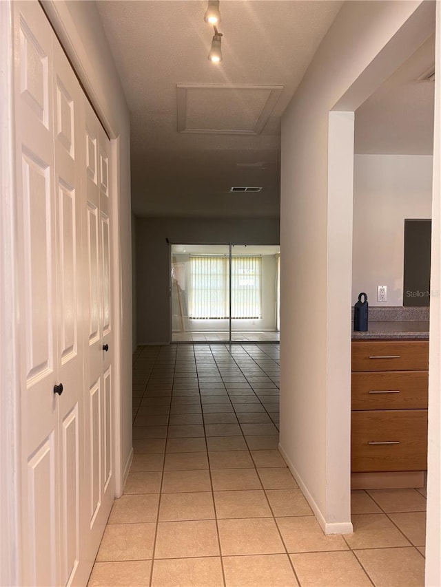 5057 Live Oak Cir Unit 86, Bradenton, FL 34207 - hallway with light tile patterned floors, attic access, rail lighting, and baseboards
