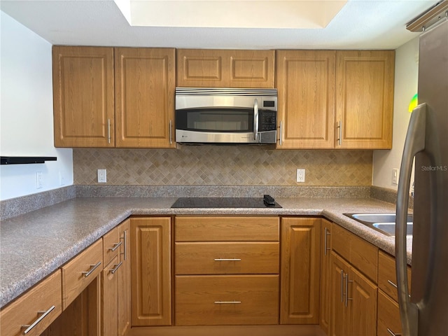 5057 Live Oak Cir Unit 86, Bradenton, FL 34207 - kitchen featuring stainless steel appliances, backsplash, and brown cabinetry