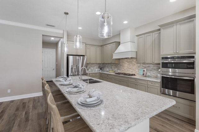 569 Mast Dr, Bradenton, FL 34208 - kitchen featuring appliances with stainless steel finishes, a sink, custom range hood, a kitchen breakfast bar, and tasteful backsplash