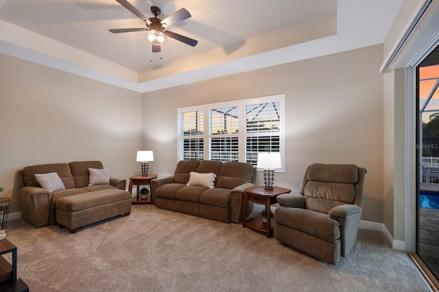 569 Mast Dr, Bradenton, FL 34208 - carpeted living area featuring a tray ceiling, a ceiling fan, and baseboards