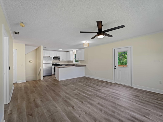 3405 10th St W, Palmetto, FL 34221 - kitchen featuring white cabinetry, a textured ceiling, open floor plan, and appliances with stainless steel finishes