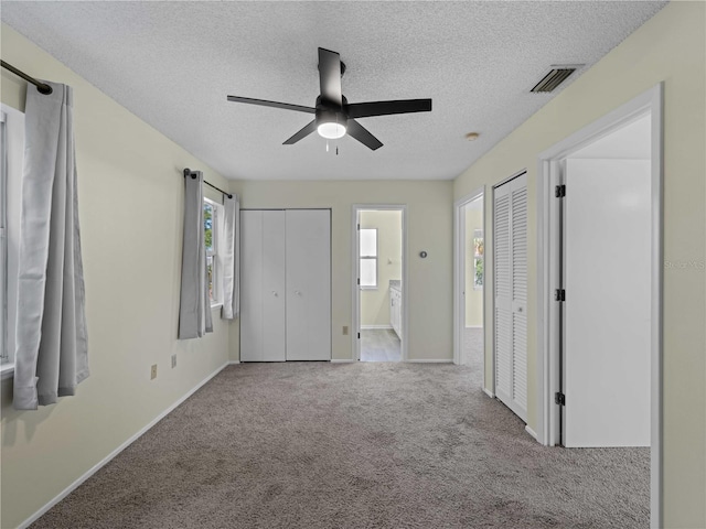 3405 10th St W, Palmetto, FL 34221 - unfurnished bedroom featuring a textured ceiling, visible vents, baseboards, carpet floors, and two closets