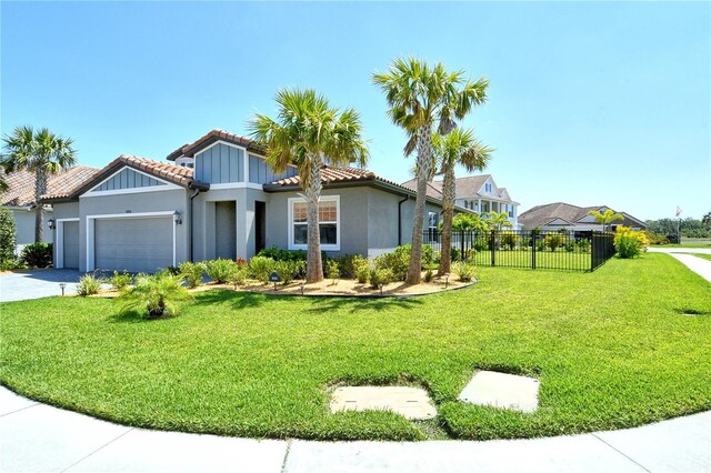 view of front of property featuring fence, a front lawn, a tile roof, a garage, and stucco siding