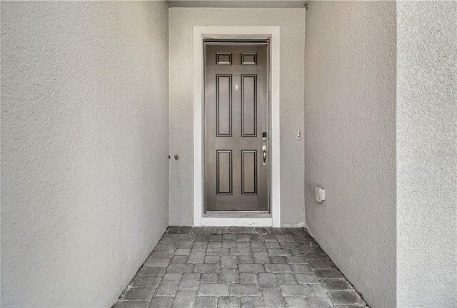 entrance to property featuring stucco siding