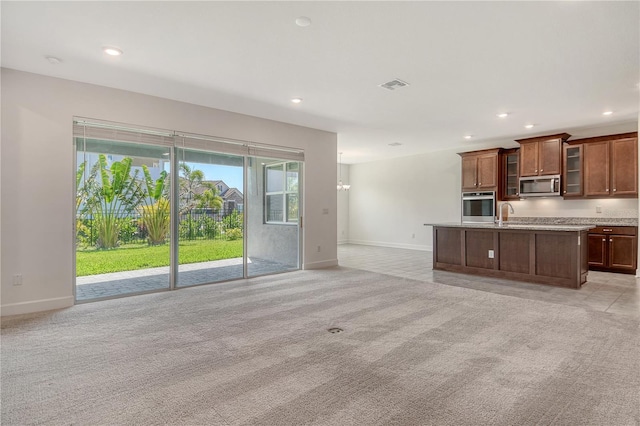 unfurnished living room with visible vents, a sink, baseboards, light carpet, and recessed lighting