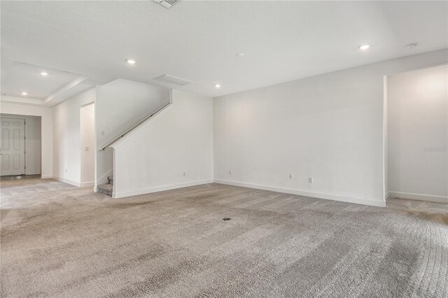 unfurnished living room featuring stairway, recessed lighting, and light colored carpet