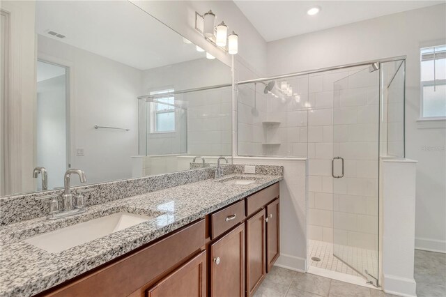 full bath featuring visible vents, a sink, a stall shower, and double vanity