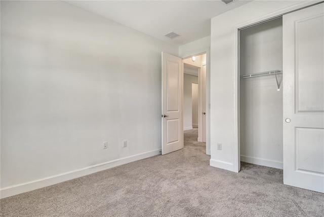 unfurnished bedroom featuring baseboards, carpet, a closet, and visible vents