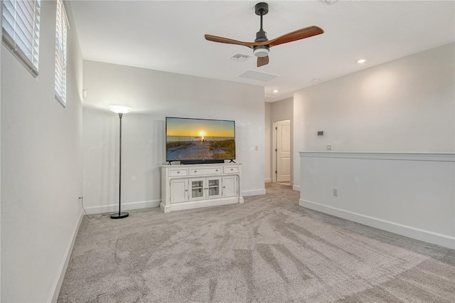 unfurnished living room with visible vents, a ceiling fan, baseboards, and light colored carpet