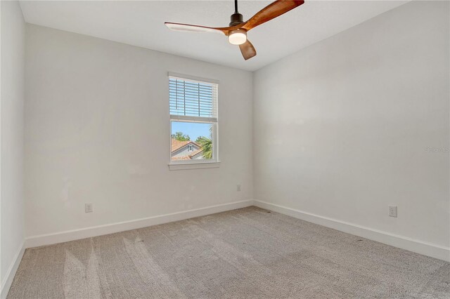 carpeted spare room with baseboards and ceiling fan