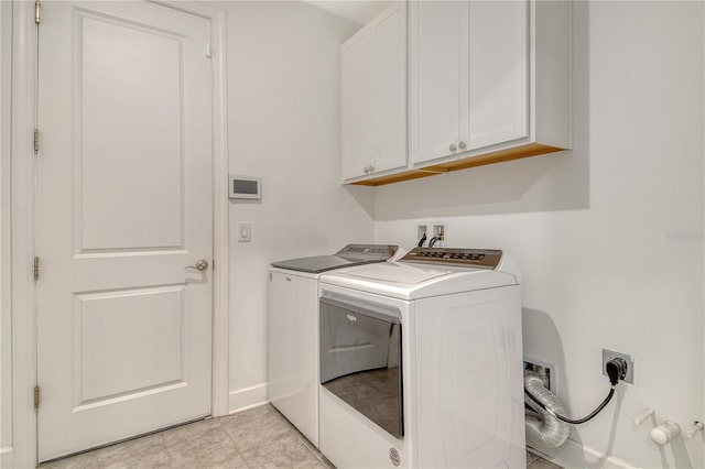 washroom with cabinet space, baseboards, and washing machine and dryer