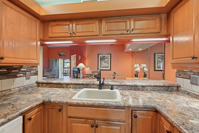 5736 Ashton Lake Dr, Sarasota, FL 34231 - kitchen with a sink, backsplash, dishwasher, a peninsula, and light stone countertops