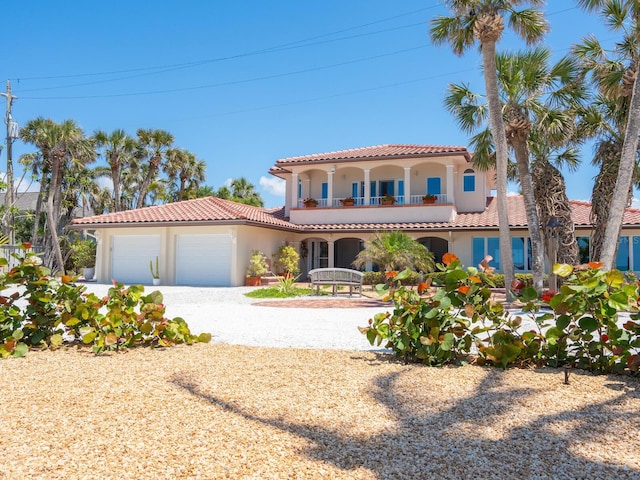 3300 Casey Key Rd, Nokomis, FL 34275 - mediterranean / spanish-style home with a balcony, a tile roof, gravel driveway, stucco siding, and a garage