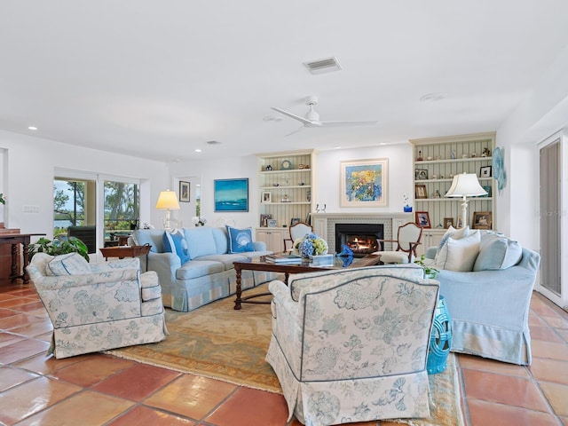 3300 Casey Key Rd, Nokomis, FL 34275 - living area with visible vents, ceiling fan, a brick fireplace, tile patterned floors, and built in shelves