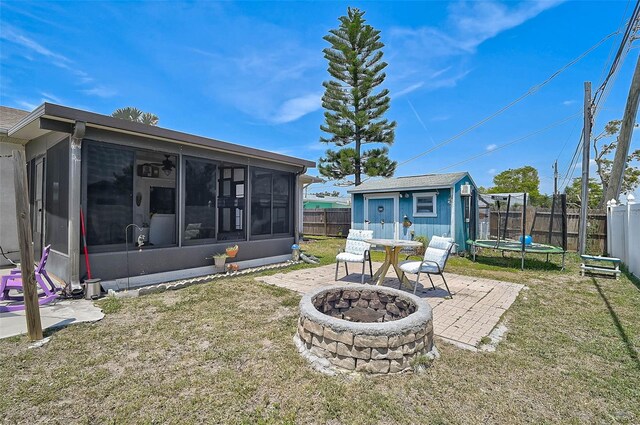 1789 Elm Dr, Venice, FL 34293 - view of yard with a fire pit, a trampoline, a shed, a sunroom, and a fenced backyard