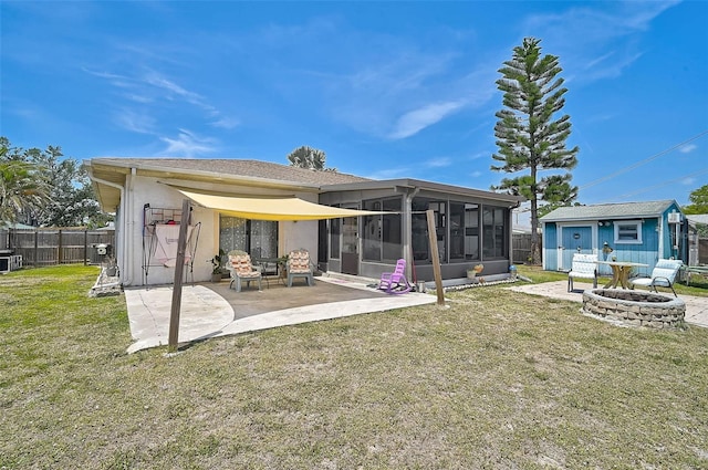 1789 Elm Dr, Venice, FL 34293 - back of property with a patio area, an outdoor fire pit, fence, a yard, and a sunroom