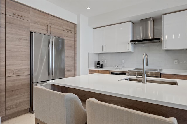 111 S Pineapple Ave Unit 716, Sarasota, FL 34236 - kitchen featuring modern cabinets, light countertops, freestanding refrigerator, a breakfast bar, and wall chimney exhaust hood