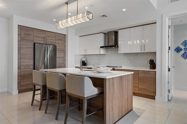 111 S Pineapple Ave Unit 716, Sarasota, FL 34236 - kitchen featuring wall chimney range hood, a sink, modern cabinets, and a kitchen bar