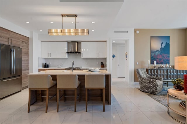 111 S Pineapple Ave Unit 716, Sarasota, FL 34236 - kitchen with visible vents, freestanding refrigerator, modern cabinets, and wall chimney range hood