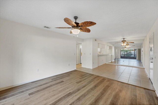 752 White Pine Tree Rd Unit 101, Venice, FL 34285 - unfurnished living room featuring light wood finished floors, ceiling fan, baseboards, and visible vents