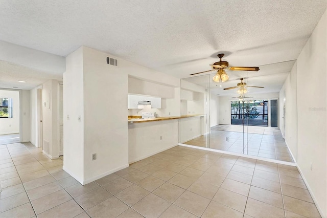 752 White Pine Tree Rd Unit 101, Venice, FL 34285 - spare room featuring light tile patterned floors, ceiling fan, visible vents, baseboards, and a textured ceiling