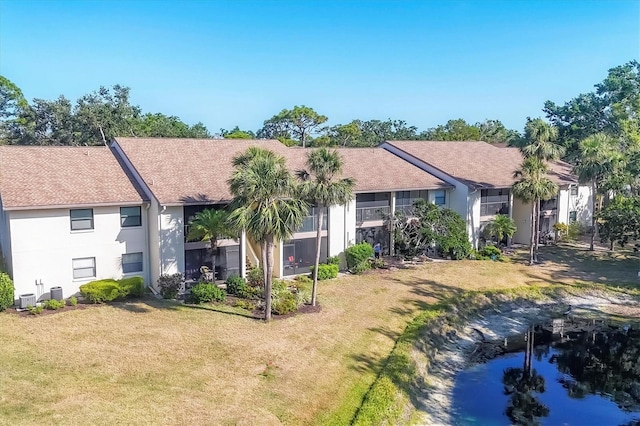 752 White Pine Tree Rd Unit 101, Venice, FL 34285 - rear view of house with central air condition unit, stucco siding, and a lawn