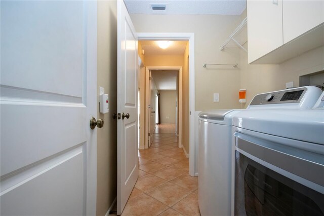 3843 El Poinier Ct W Unit 8720, Sarasota, FL 34232 - clothes washing area with washer and clothes dryer, light tile patterned flooring, and cabinet space