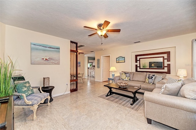 living room featuring visible vents, ceiling fan, and baseboards