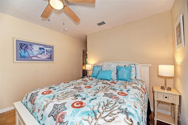 bedroom featuring wood finished floors, visible vents, ceiling fan, and baseboards