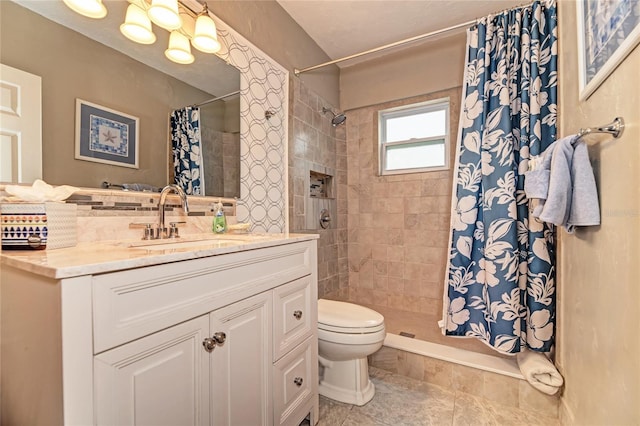 bathroom with toilet, a tile shower, and vanity
