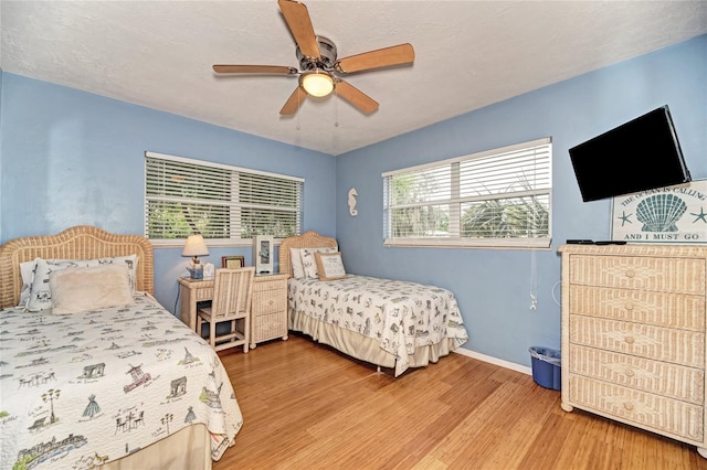 bedroom with baseboards, wood finished floors, and ceiling fan
