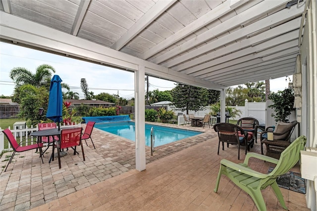 view of swimming pool with outdoor dining space and a fenced backyard