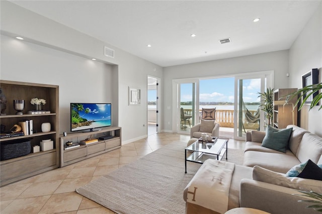 living area featuring baseboards, visible vents, light tile patterned floors, and recessed lighting