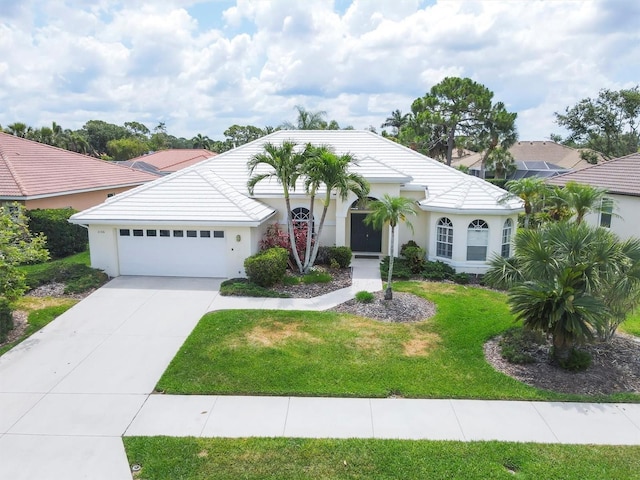 5106 Far Oak Cir, Sarasota, FL 34238 - view of front of property featuring an attached garage, a front lawn, stucco siding, a tiled roof, and driveway