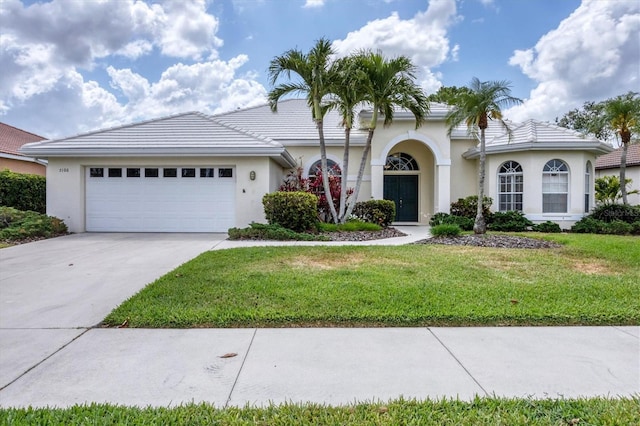5106 Far Oak Cir, Sarasota, FL 34238 - mediterranean / spanish-style house with a tile roof, a garage, stucco siding, a front yard, and driveway